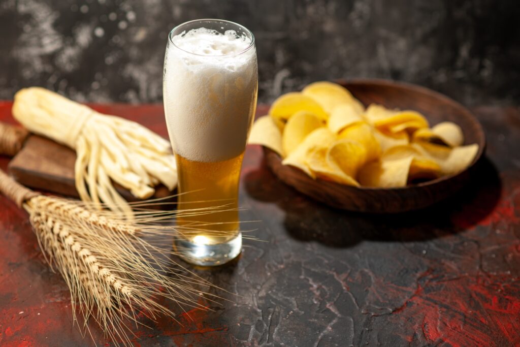 Glass of hazy Pterodactyl Hefeweizen served with chips and melted cheese pairing at Little Miami Brewing Company.