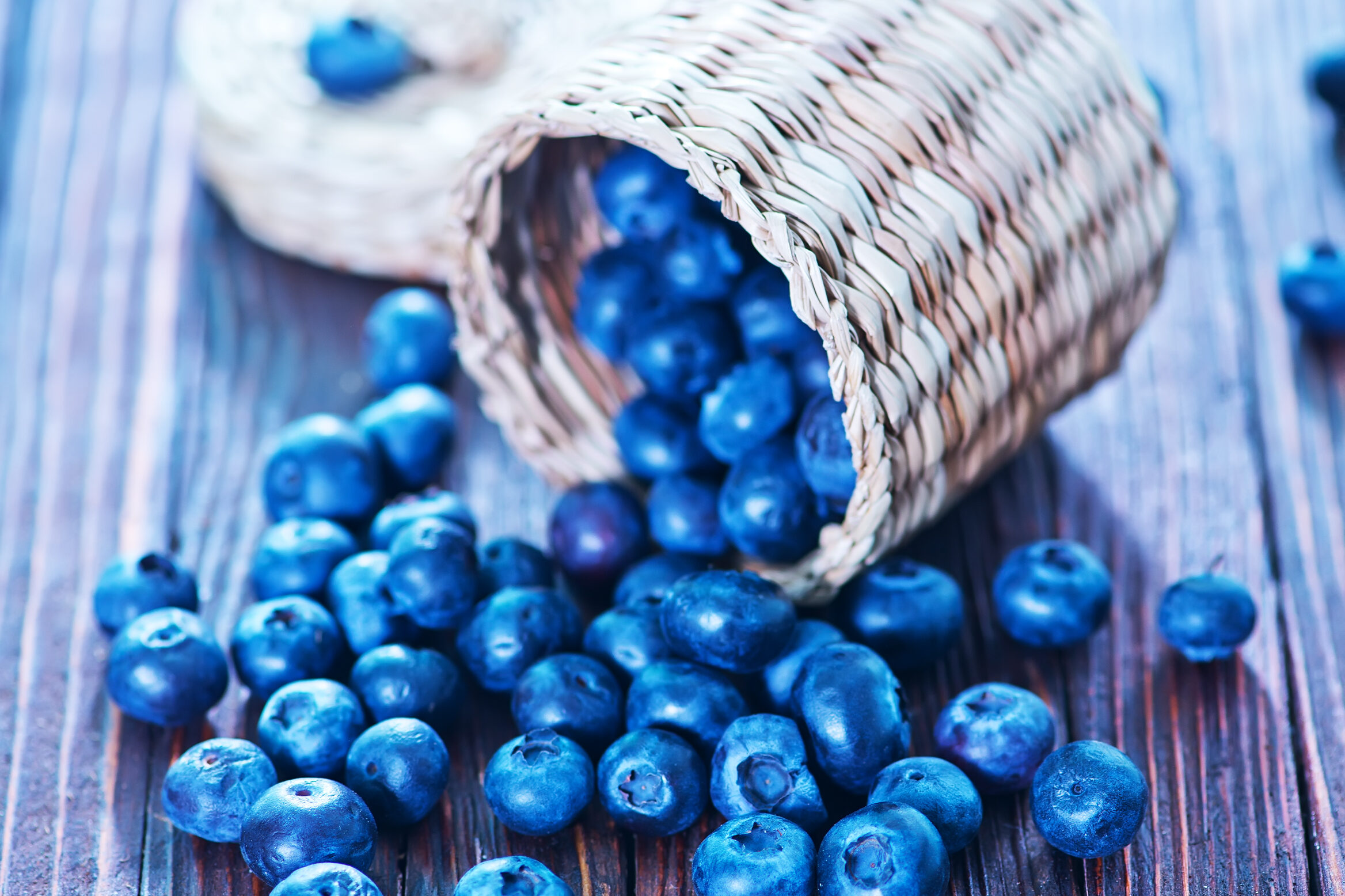 Fresh blueberries spilling from a wicker basket Fresh blueberries spilling from a wicker basket onto a rustic wooden surface, highlighting the natural ingredients used in blueberry beer
.