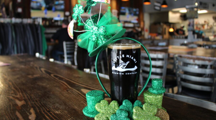 A dark stout from Little Miami Brewing Company served with shamrocks and a green hat, evoking a festive atmosphere.
