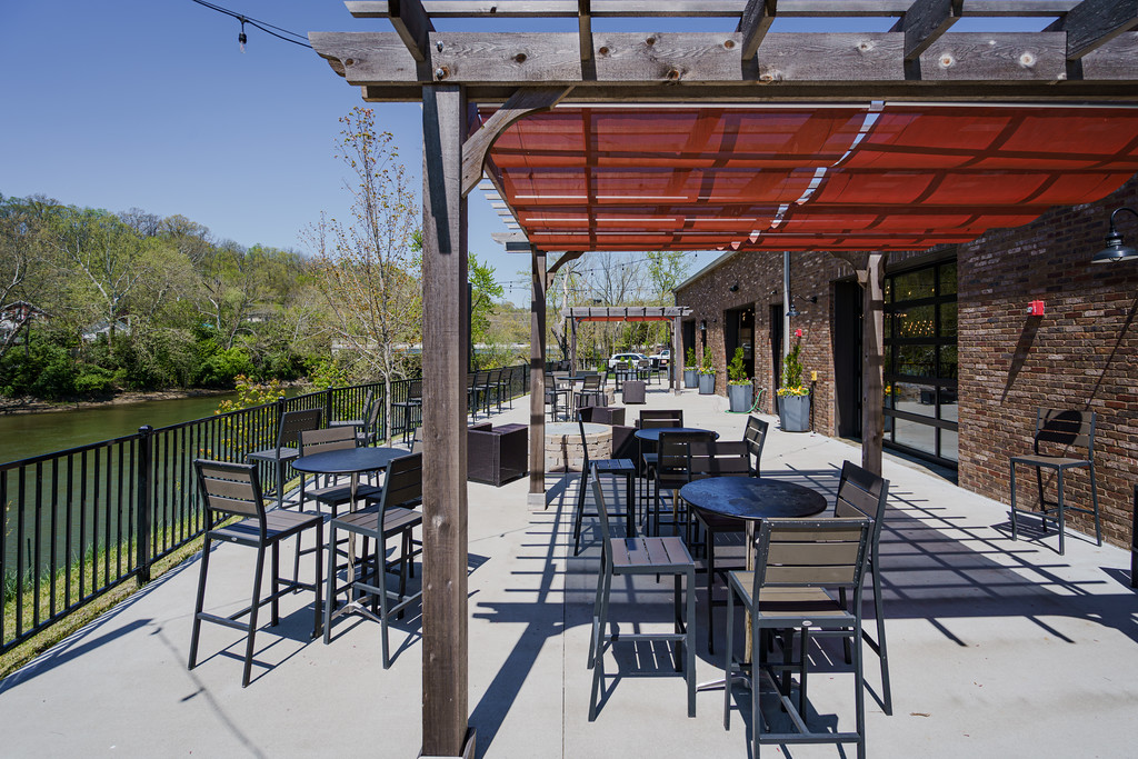 Riverside patio of Little Miami Brewing Co. overlooking the Little Miami River during golden hour in Milford, Ohio.